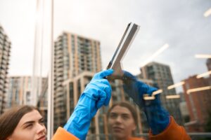 Cleaning service cleaner washes the mirrored windows of office center